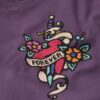 Camiseta ajustada con pequeño tatuaje de pedrería